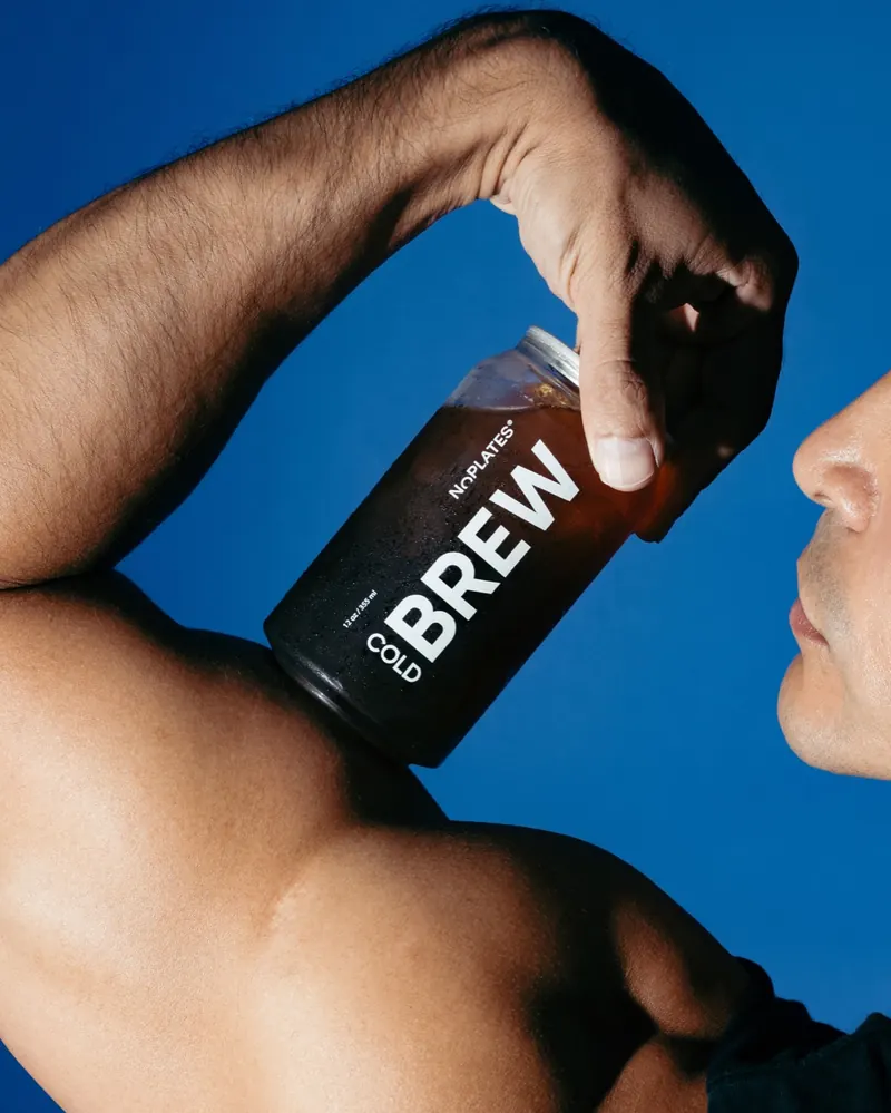 An athlete drinking a No Plates cold brew can